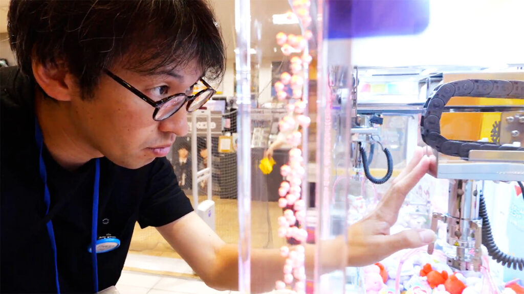 クレーンゲームをメンテナンスする男性