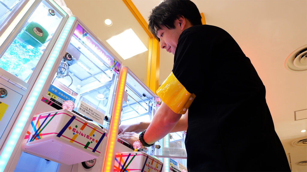 クレーンゲームをメンテナンスする男性